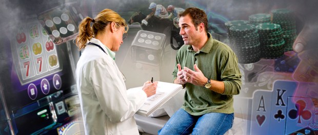 A doctor taking notes while talking to a man about gambling problems.