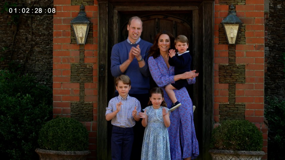 The Cambridge family clapping in front of their home.