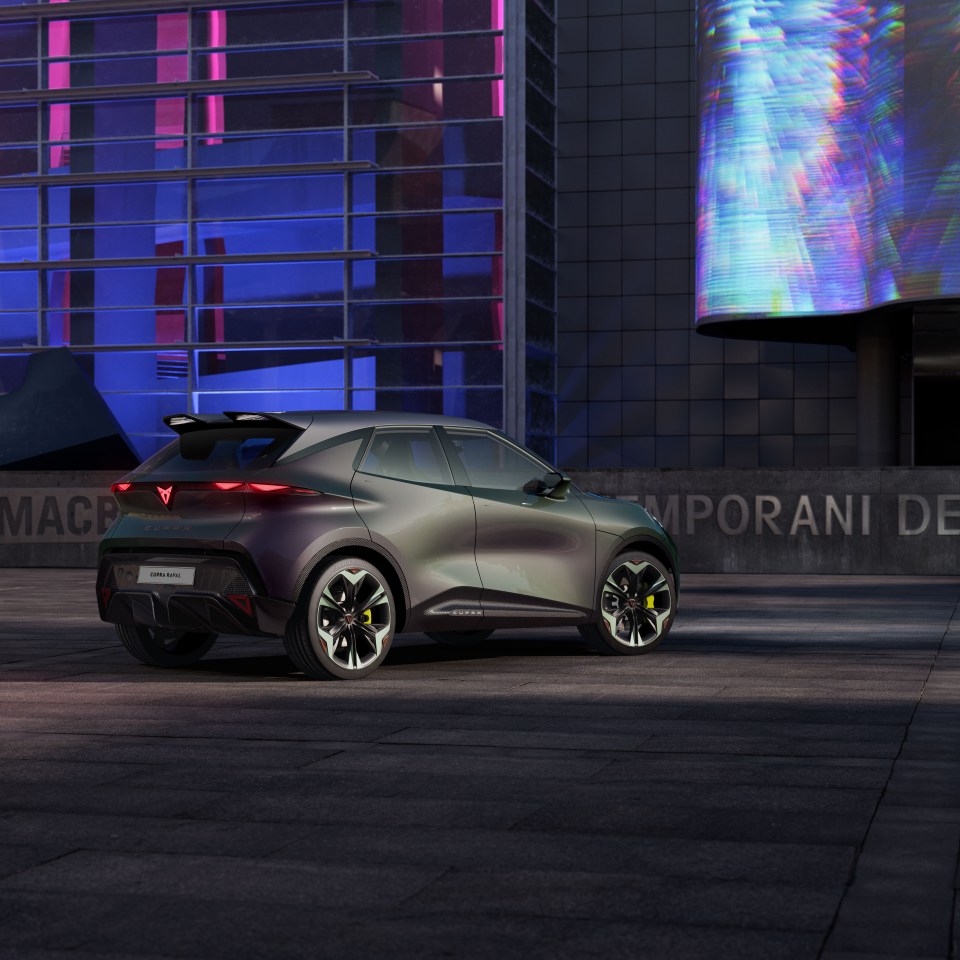 CUPRA Raval concept car parked in front of a modern building.