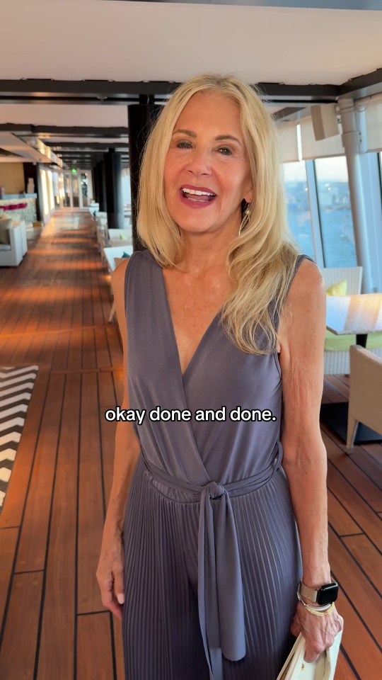 Woman in gray jumpsuit on a ship's deck.