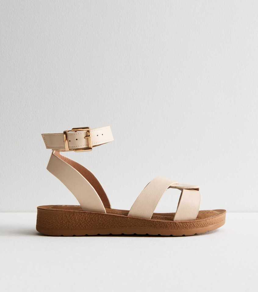 Beige sandals with ankle strap and brown sole.