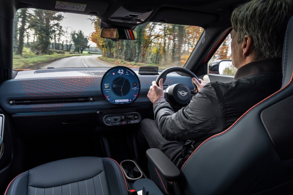 Man driving a Mini Cooper.