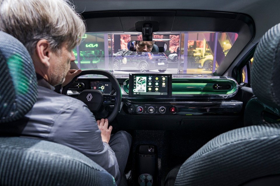 Man driving a car with a green dashboard.