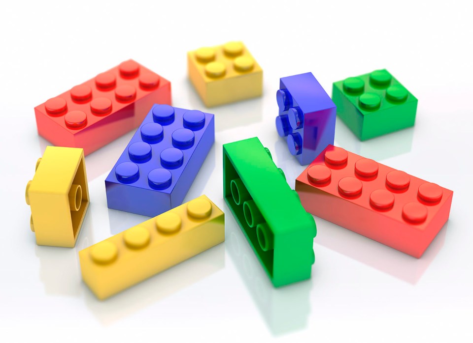 Colorful plastic building blocks scattered on a white surface.