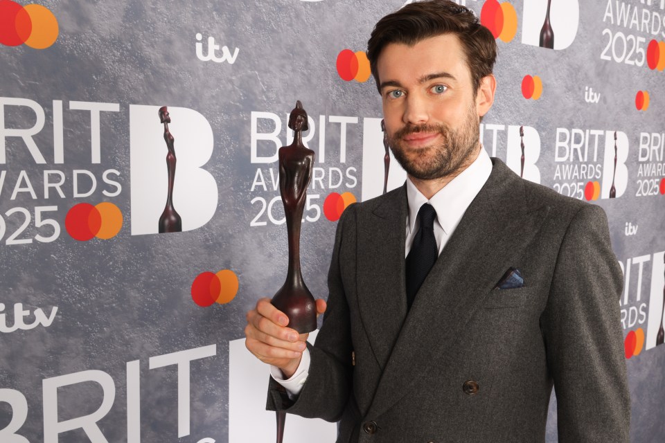 Jack Whitehall holding a BRIT Award.