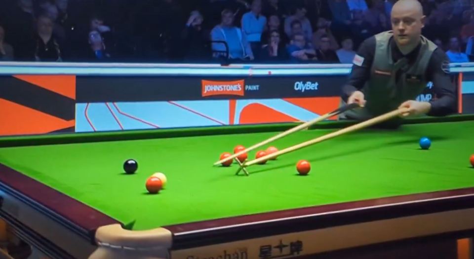 Snooker player lining up a shot.