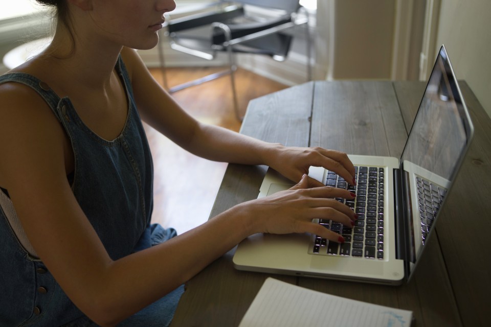 Woman typing on a laptop.