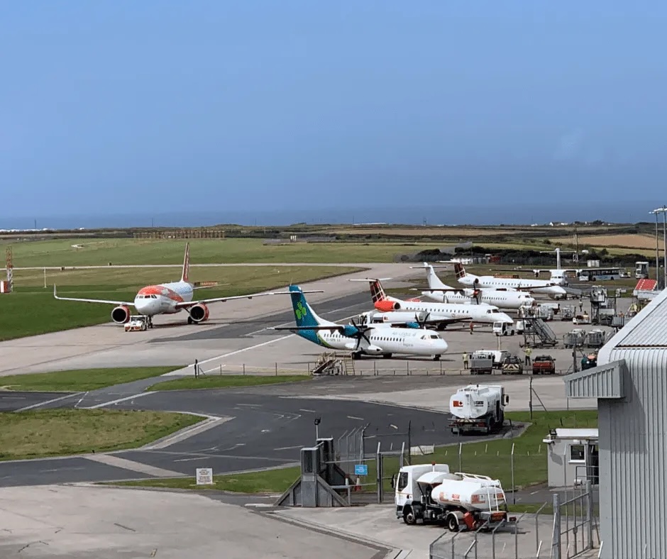 Several airplanes parked at an airport tarmac.