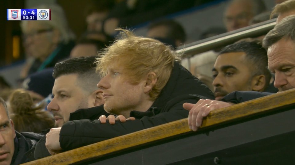 Ed Sheeran watching a soccer game.