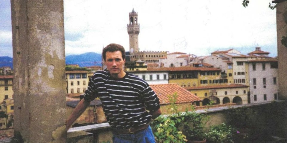 Man in striped shirt on a rooftop overlooking Florence, Italy.