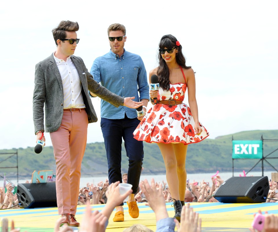 Three presenters at an outdoor event.