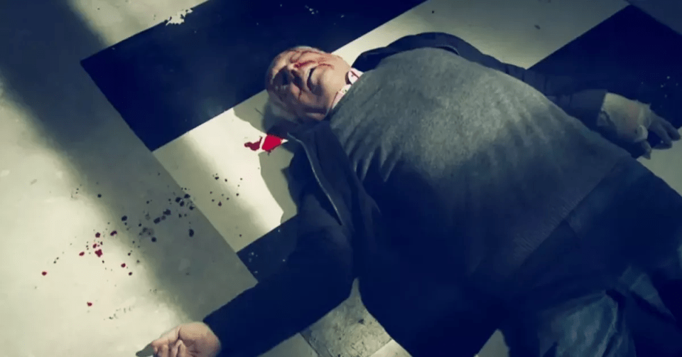 A bloody man lying on the floor.