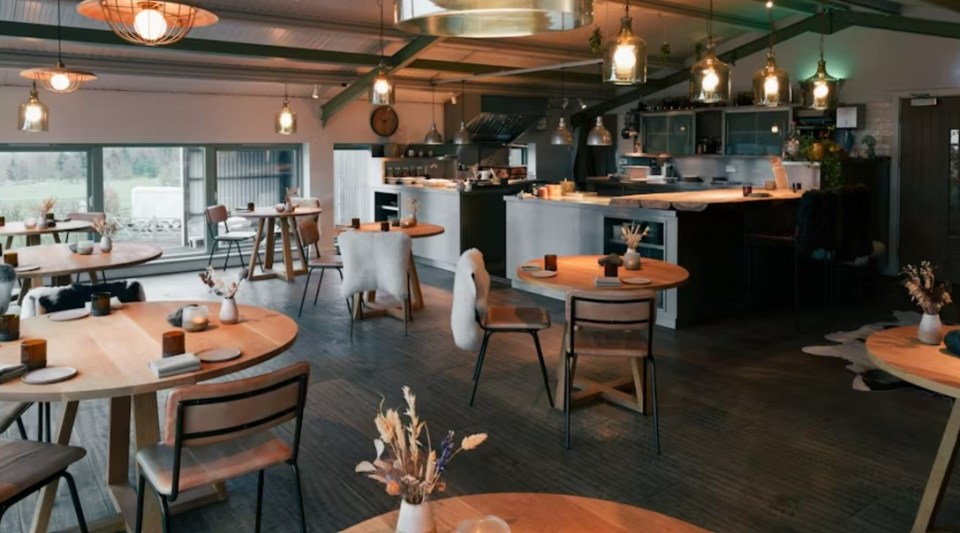 Interior view of a restaurant with wooden tables and chairs.