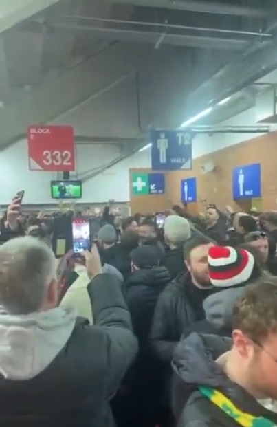 A large crowd of people in a stadium corridor.