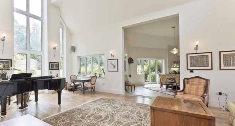 Grand living room with piano, large windows, and open floor plan.