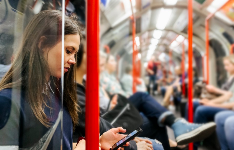 Woman on a subway using her phone.