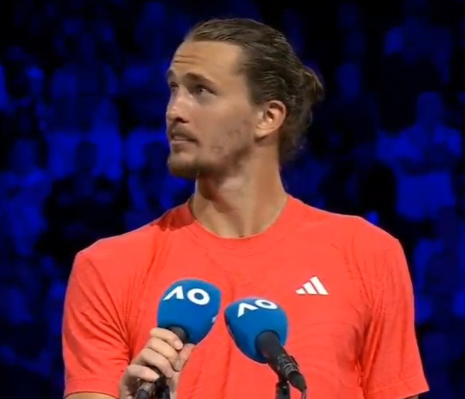 Man in orange shirt at a press conference.