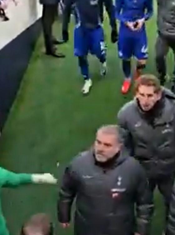 Soccer coaches and players in a tunnel.