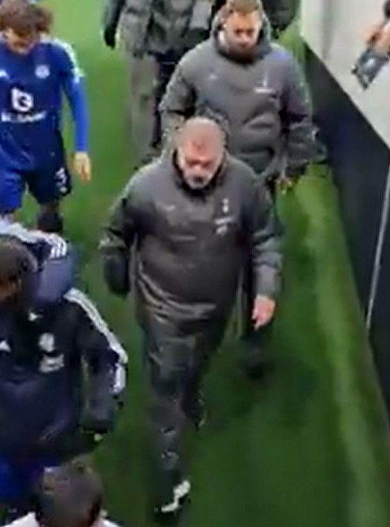 Soccer players and coaches walking down a hallway.