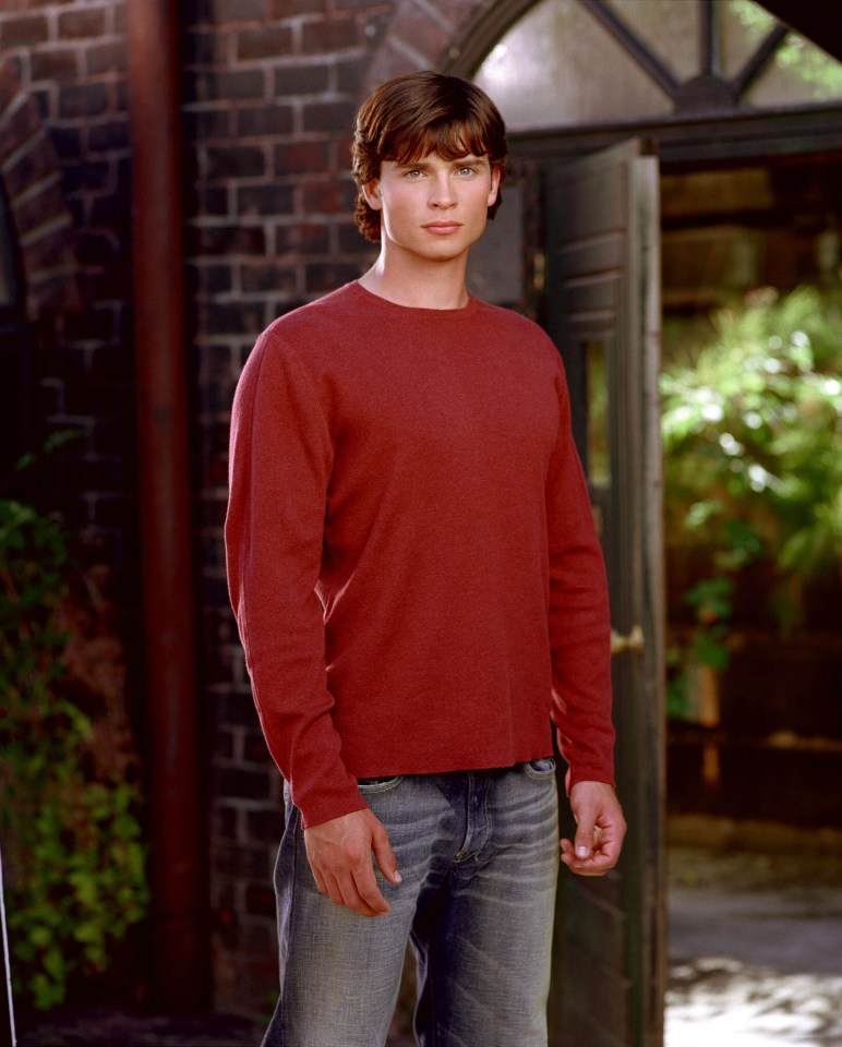 Tom Welling in a red sweater and jeans.