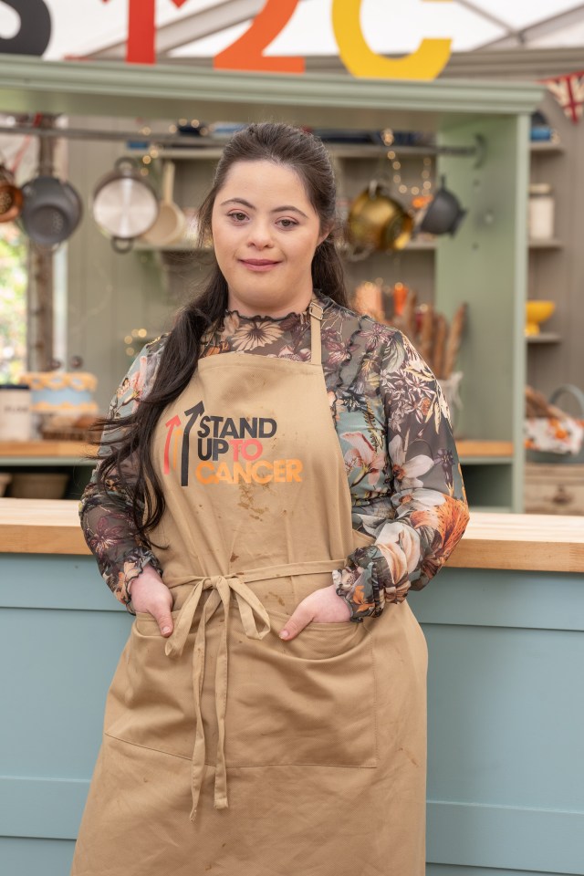 Woman wearing a Stand Up To Cancer apron.