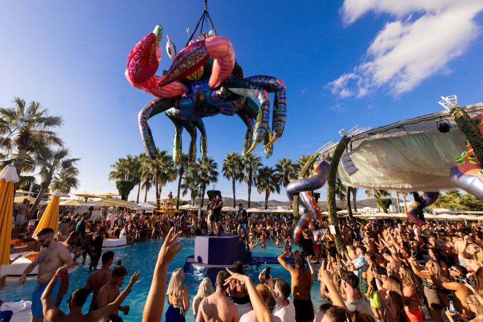 Large inflatable crab over a pool party.