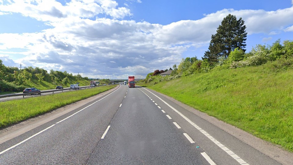 A multi-lane highway with a red lorry in the distance.