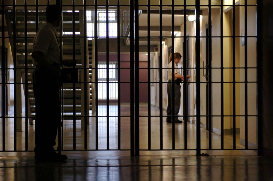 Prison guard at a gate in a women's prison wing.