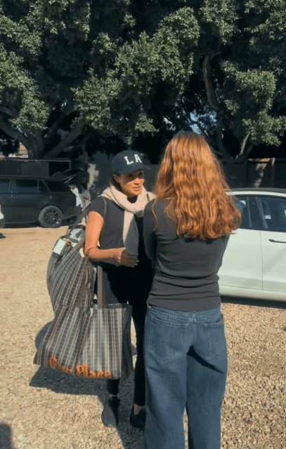 Meghan Markle talking to a woman.