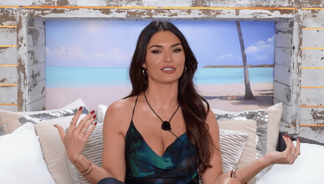 Woman sitting and talking in front of a beach backdrop.