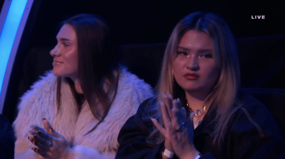 Screenshot of two women clapping.