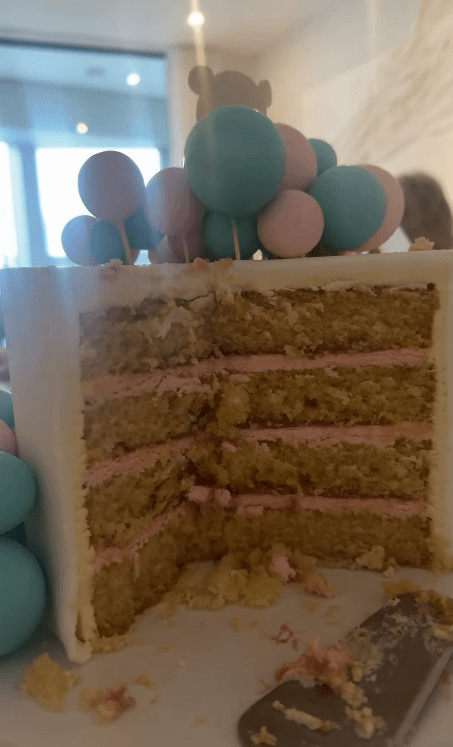 A multi-layered cake decorated with pastel balloons.