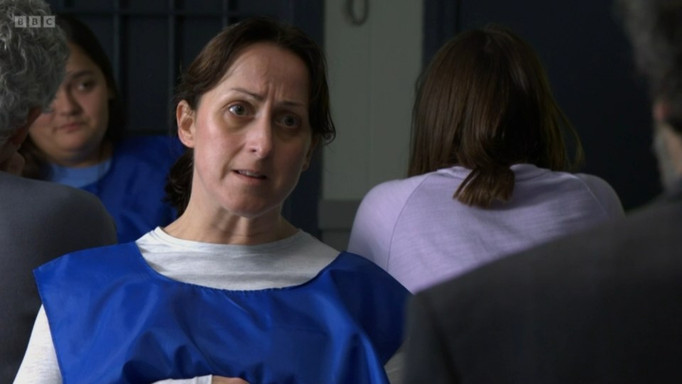 Screenshot of a woman in a blue prison vest speaking to someone off-camera.