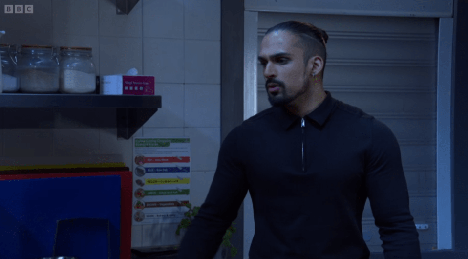 Man in a black shirt in a kitchen.