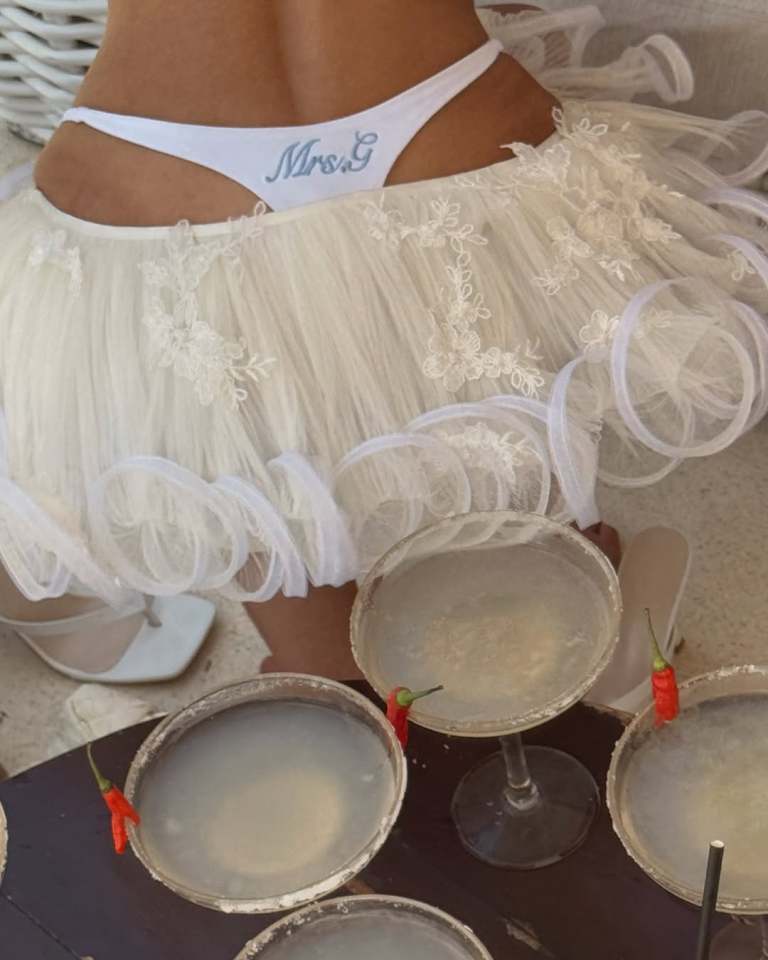 Woman in a white tulle skirt and "Mrs. G" thong, with margaritas.