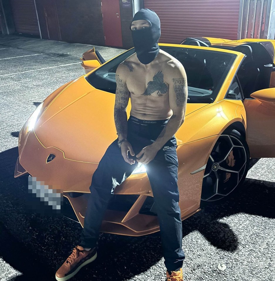 Man in balaclava sitting on orange Lamborghini.