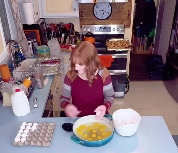 A mother of 11 preparing eggs in her kitchen.