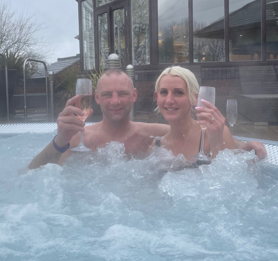 Couple relaxing in a hot tub with champagne.