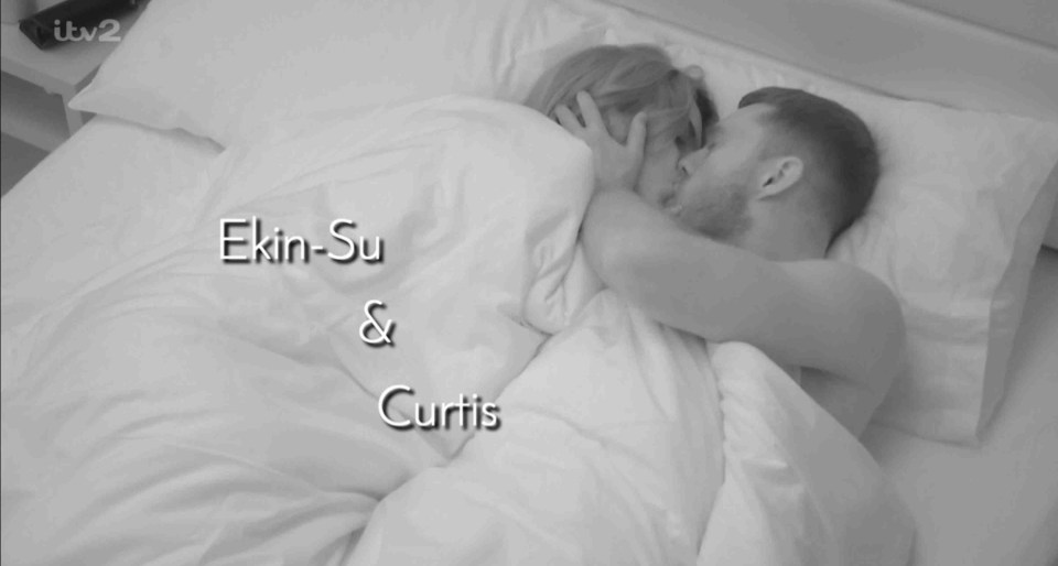 Ekin-Su and Curtis kissing in bed.