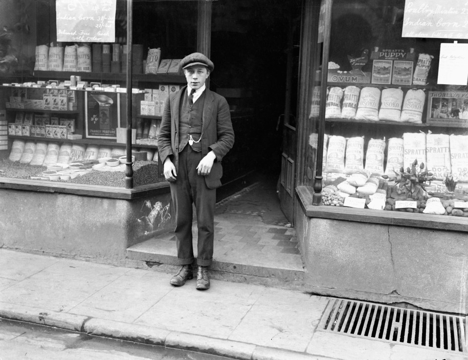 Black and white photo of a teenage boy standing outside a shop, accused of murder.