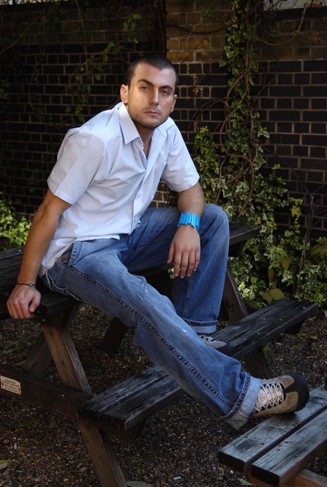 Portrait of Paul Danan sitting on a park bench.