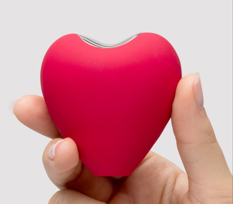 Heart-shaped device held in a hand.