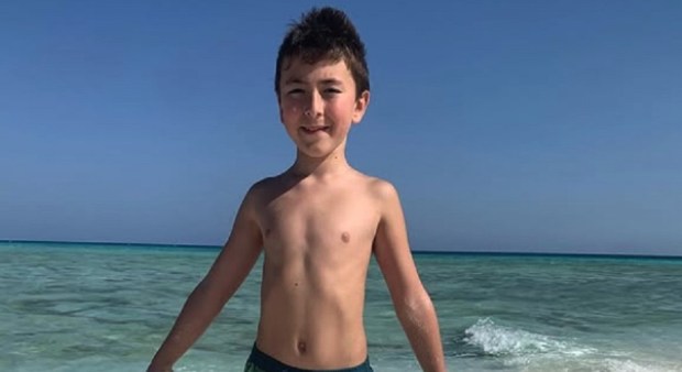 Photo of Mattia Cossettini, a nine-year-old boy, on a beach.