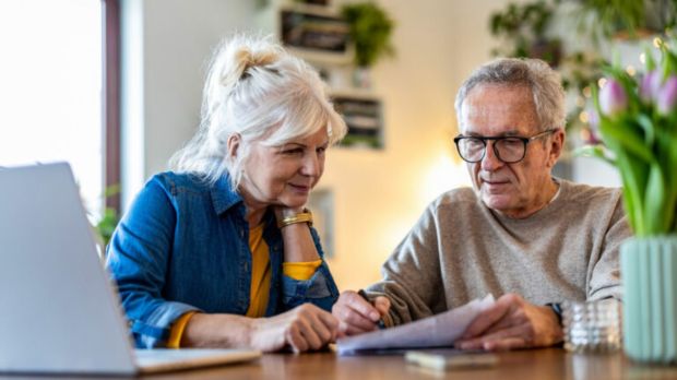 Senior couple reviewing paperwork together at a table.