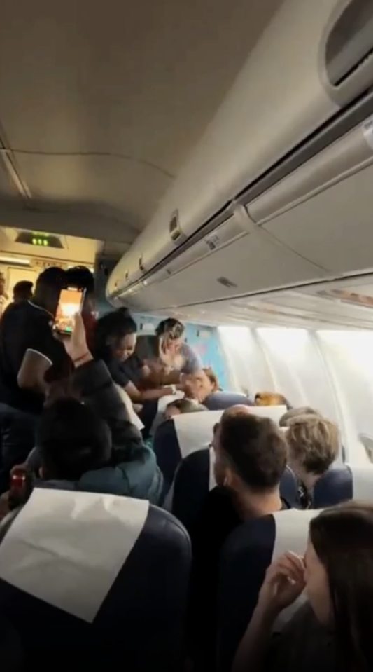 Refusing the restraint, the woman throws her drink straight at the crew member's face