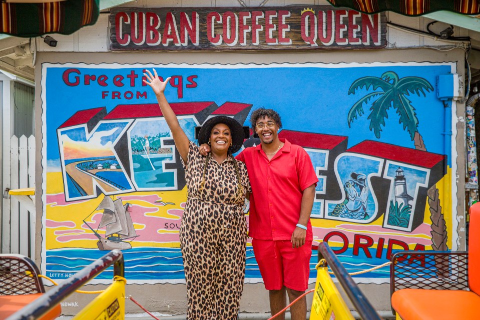 Two people posing in front of a Key West mural.