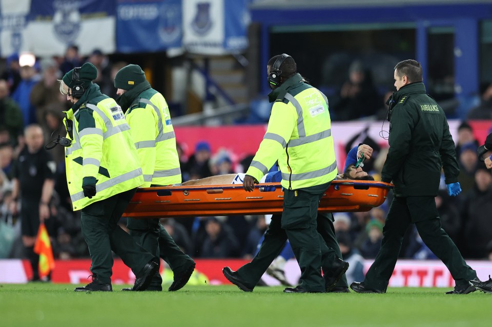 Medics carry an injured soccer player off the field on a stretcher.