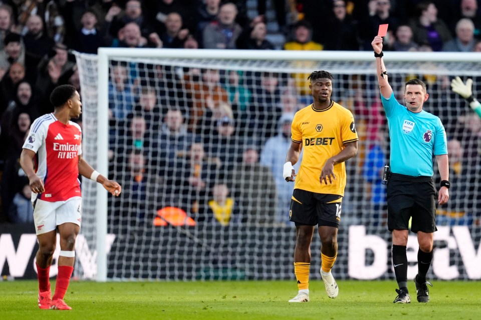 Referee showing a soccer player a red card.