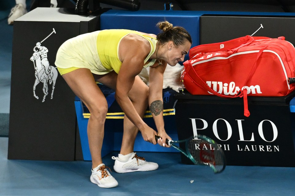 Aryna Sabalenka smashing her tennis racket after a defeat.