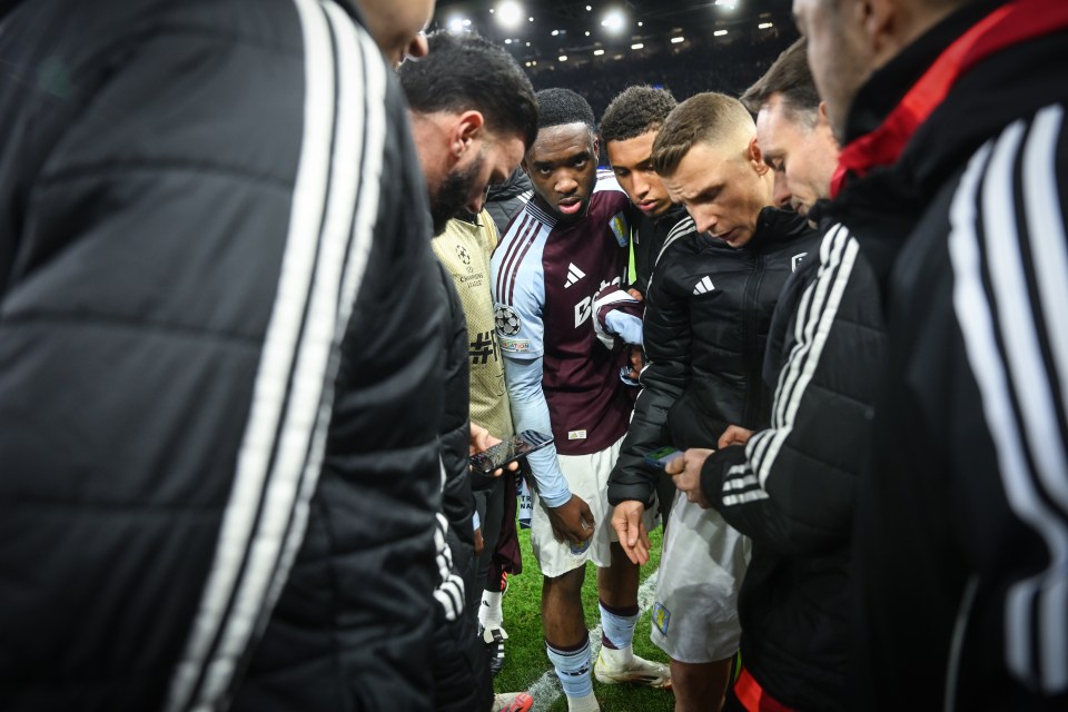 Aston Villa players checking scores on phones after a match.